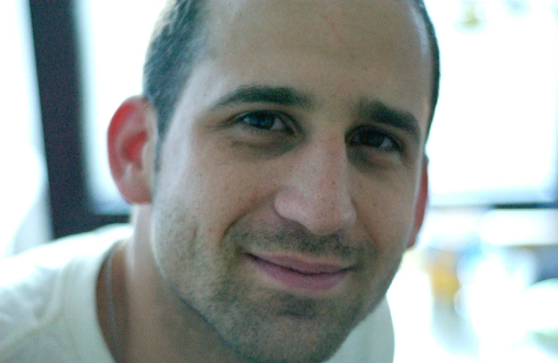 a man posing with a tie in front of a window