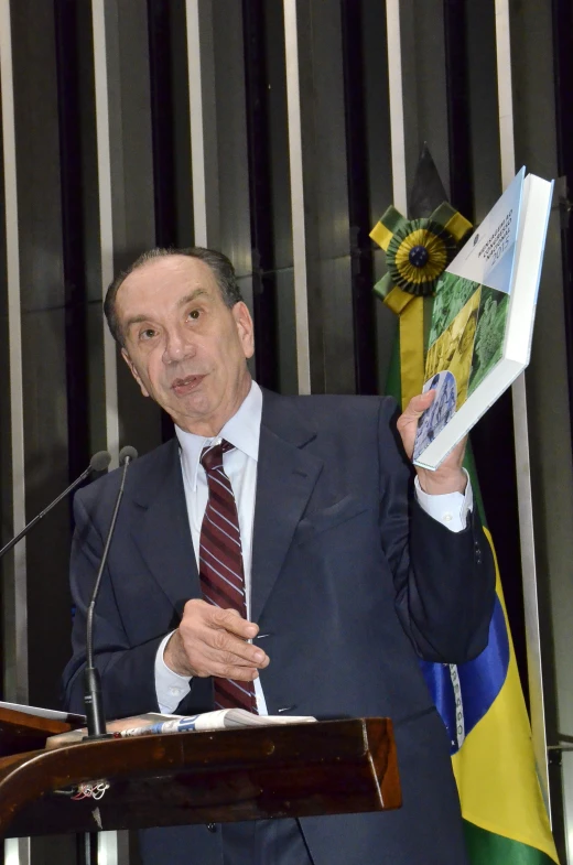 a man stands at a podium while presenting a paper