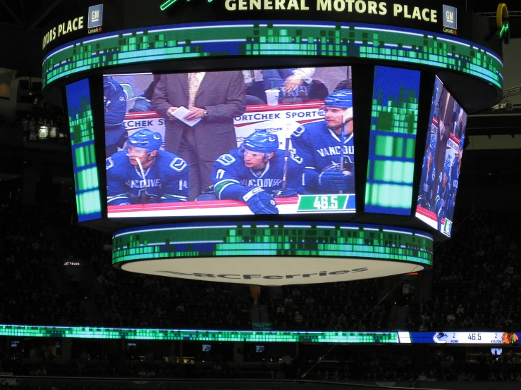 a big screen in a sporting center with some guys on it