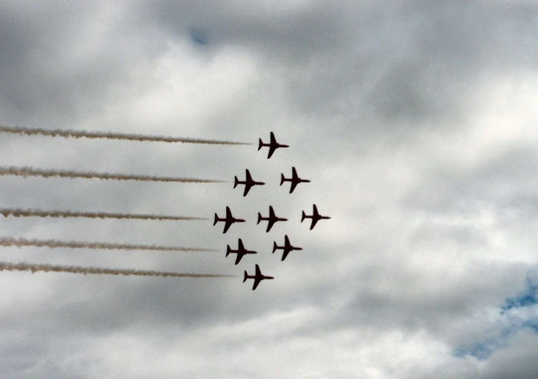 six airplanes flying in formation in a cloudy sky