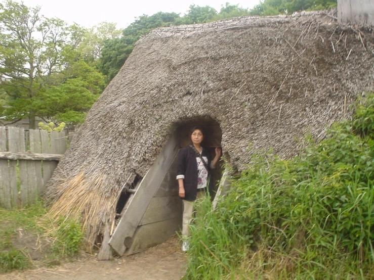 woman standing in doorway that has mud structure on top