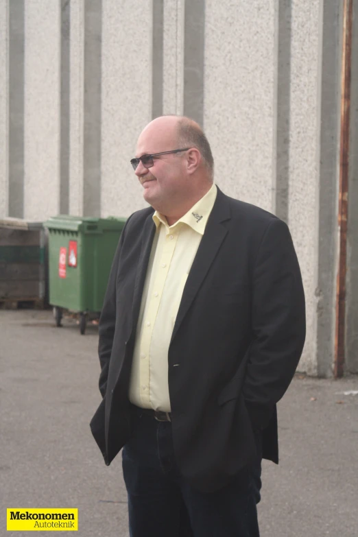 an older man in a suit standing on the pavement