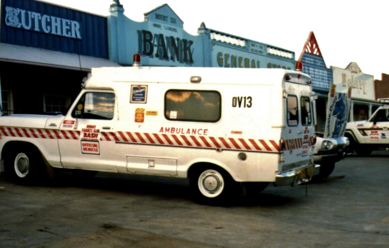 a white ambulance parked on a street next to other vehicles