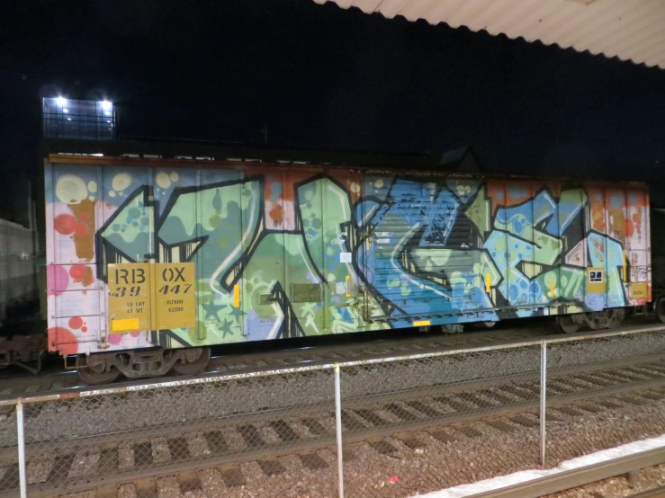 a train with many graffiti on it parked at the station