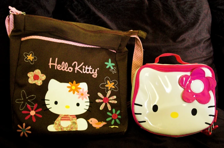 a hello kitty backpack and small lunch bag on a black background
