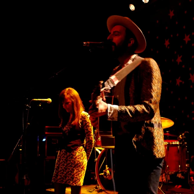 a person standing on a stage holding a guitar