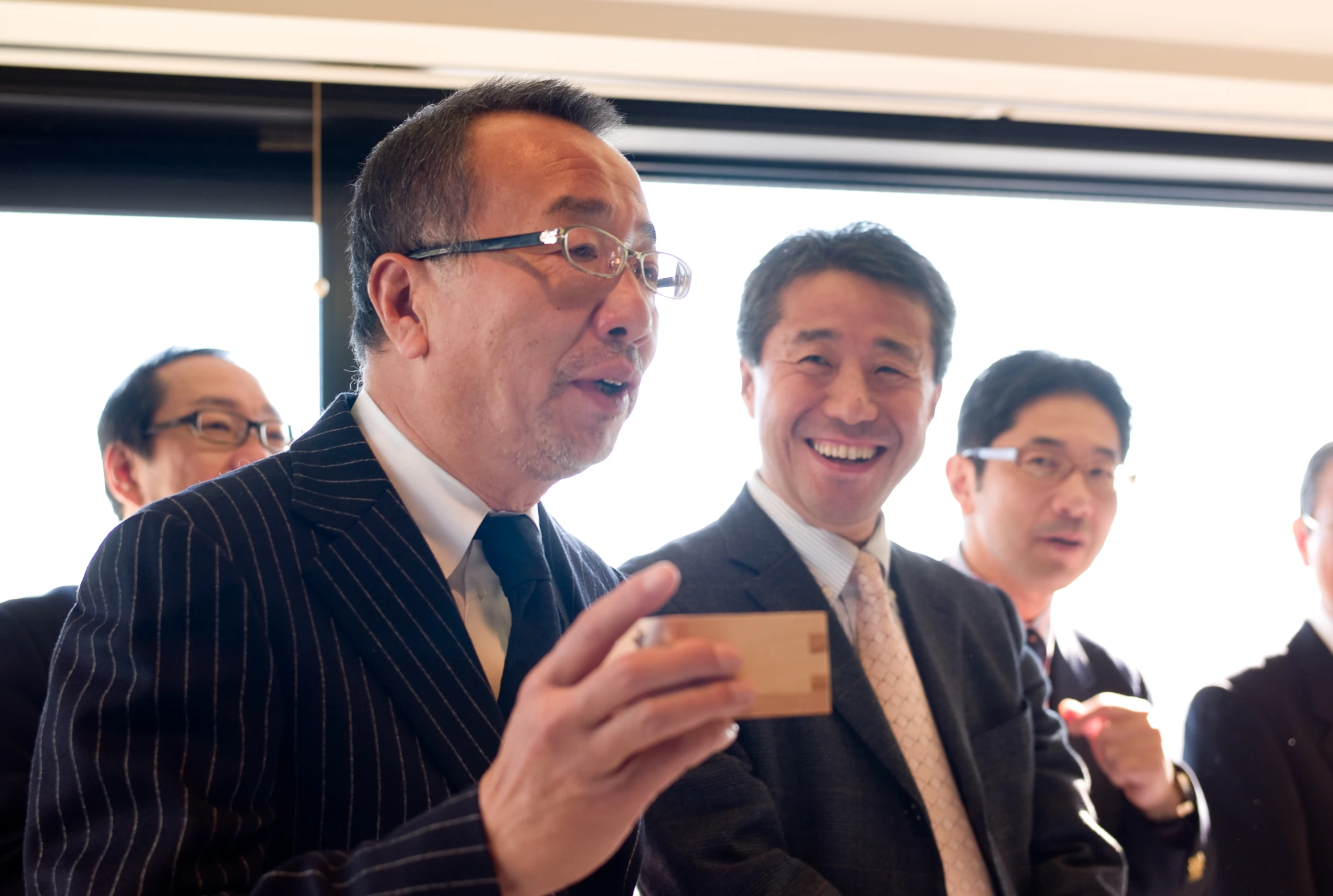 three men standing in a group one wearing a suit