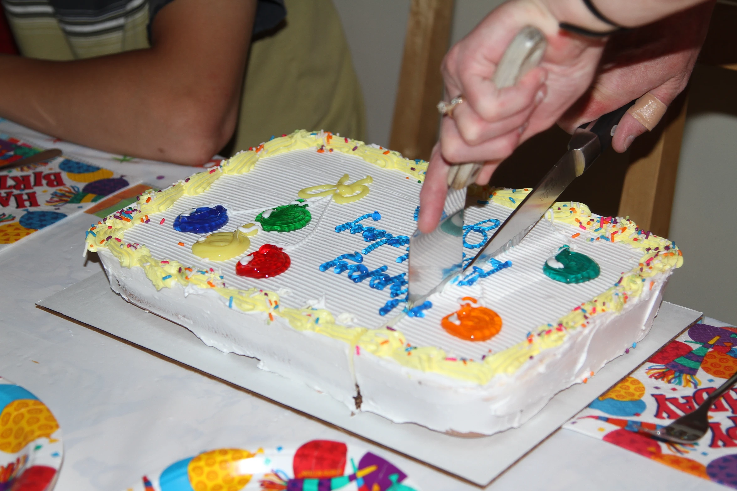 a cake being cut with a knife and another person is  a slice