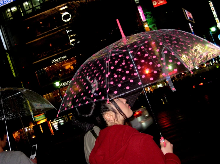 the woman is looking at a city street and it's lights