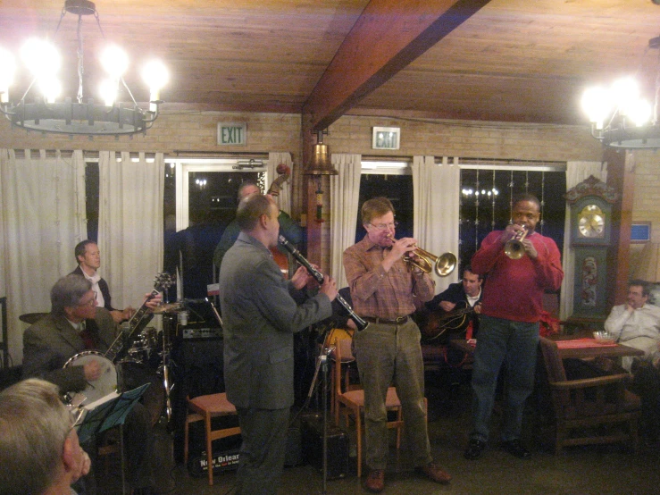 a group of people play instruments in front of some curtains