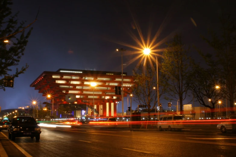 cars driving on the street with a light that is brightly lit