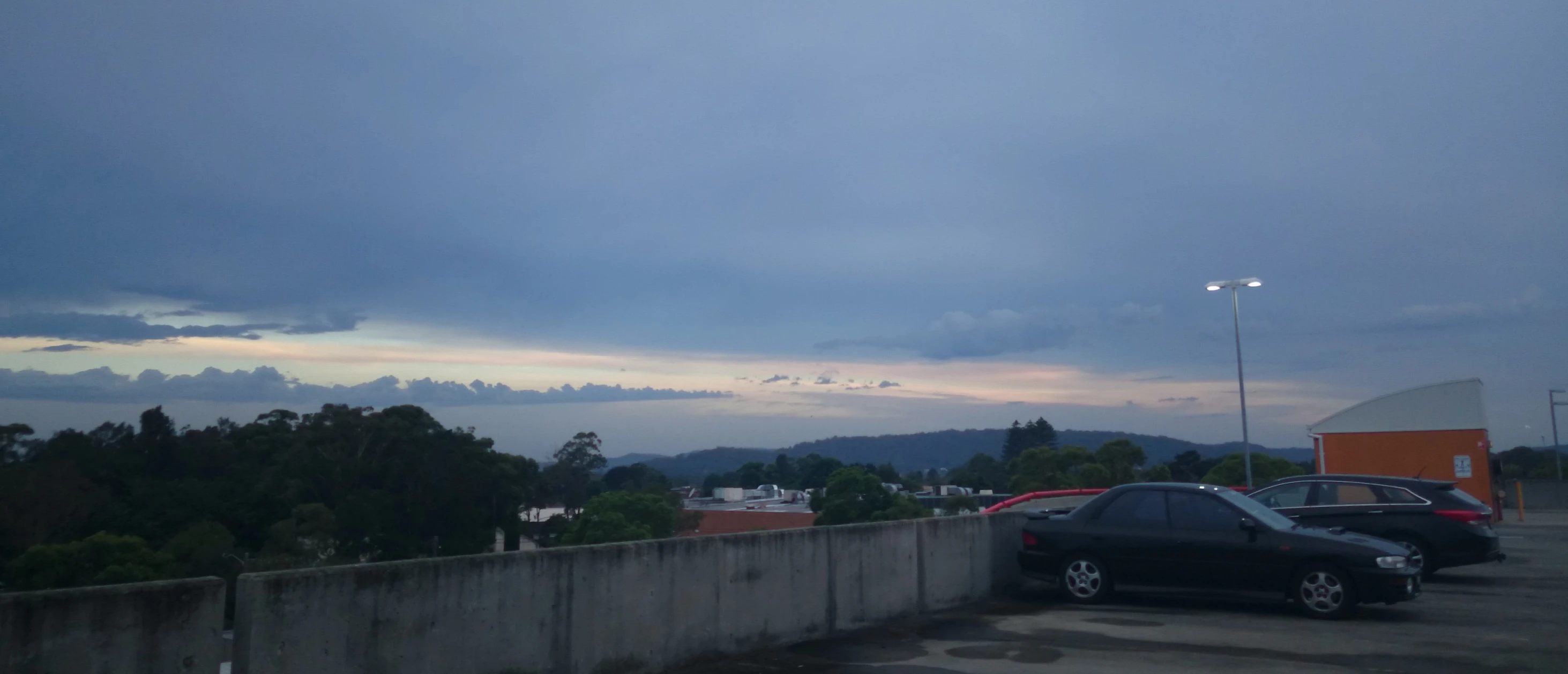 a picture of clouds in the sky and a line of cars