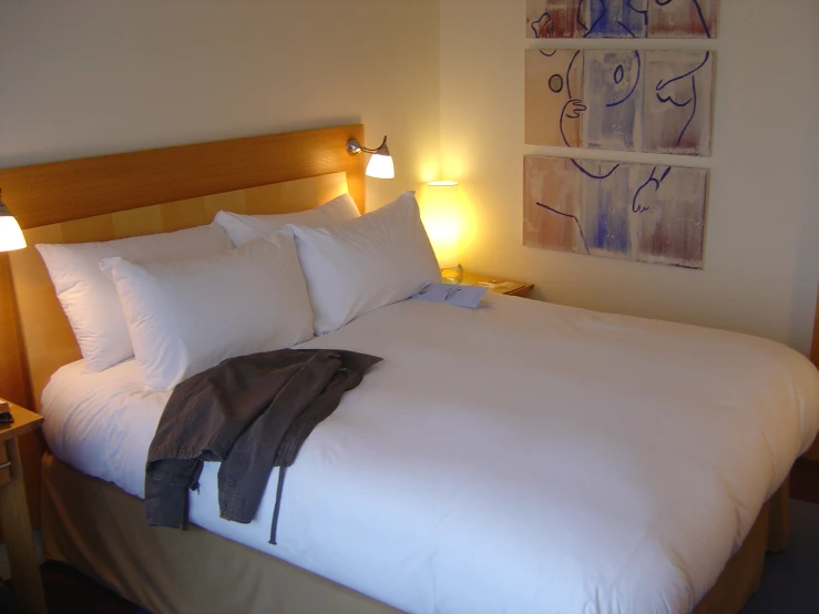 a large bed with white sheets and pillows