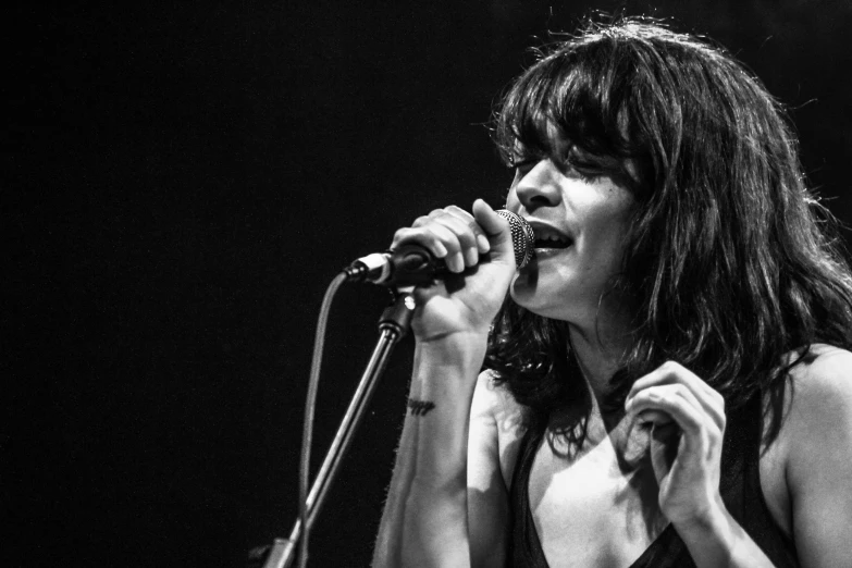 a woman on stage holding a microphone up to her mouth