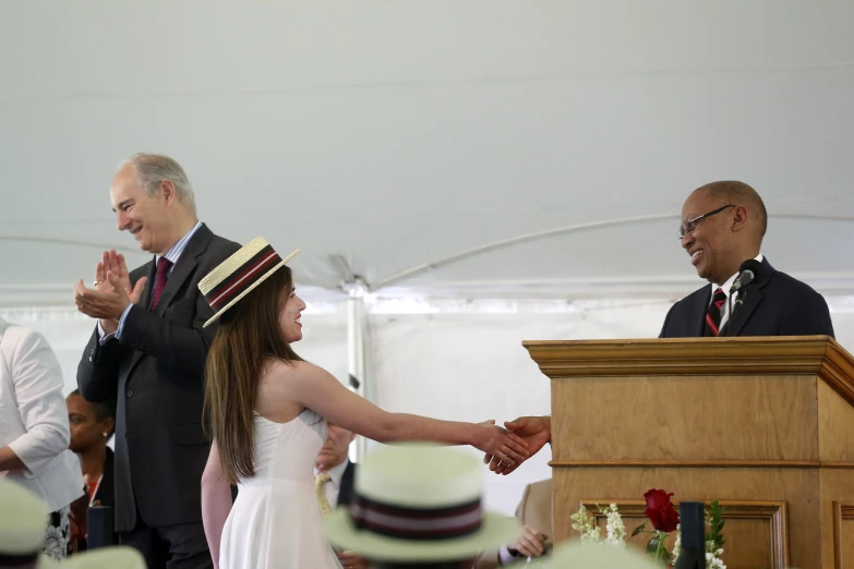 a young woman shaking hands with a younger man