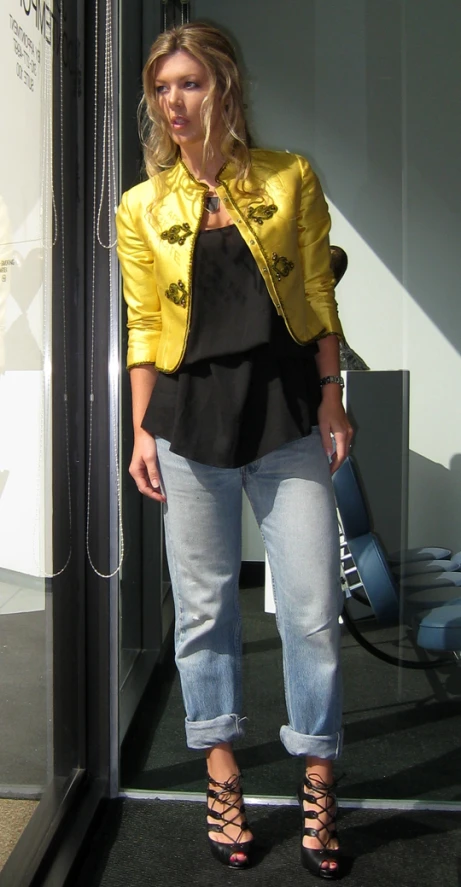 a woman standing in an elevator holding a handbag