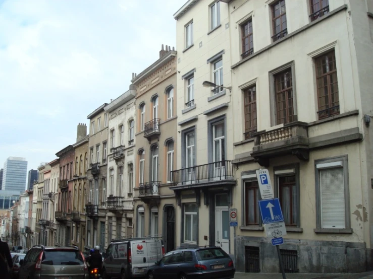 there are many cars parked next to a row of buildings