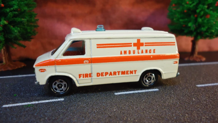 toy ambulance on the road next to a red and white sign
