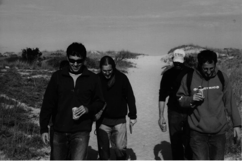 black and white pograph of three men walking down a path in a field