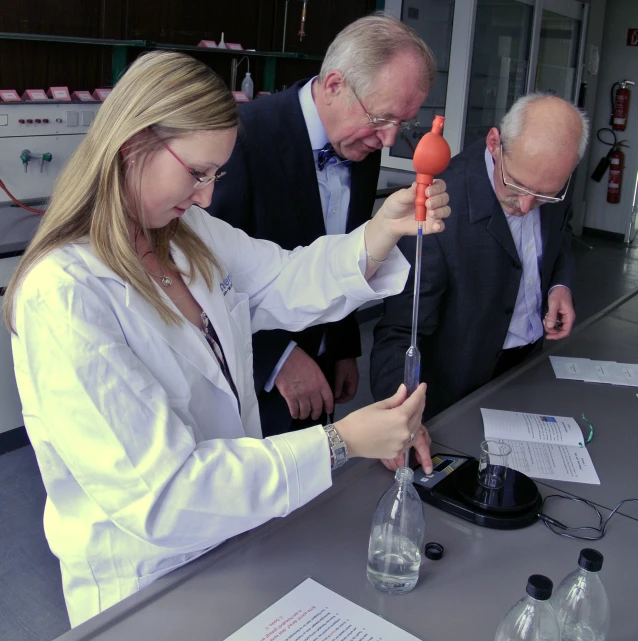 three people looking at soing in the air near a table