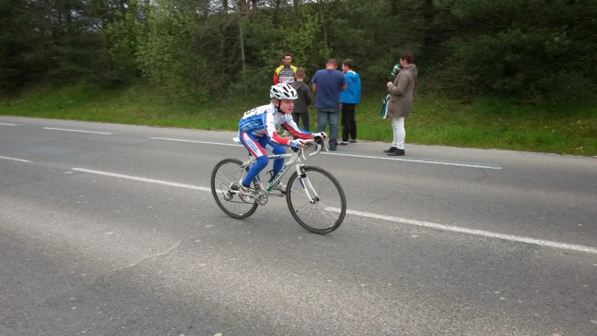 a man riding a bike down a street while wearing a crown