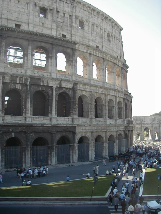 tourists walk in front of the ancient roman building