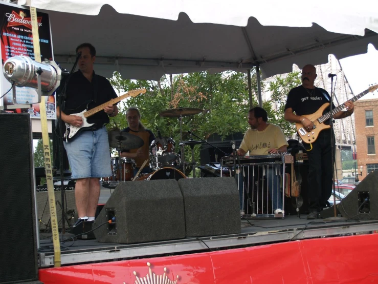 a group of people that are playing guitars on a stage