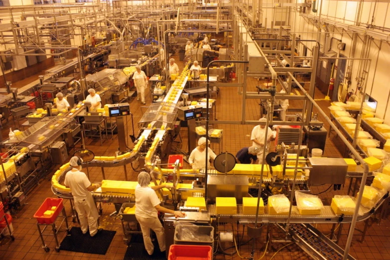 a large factory filled with workers producing cheese