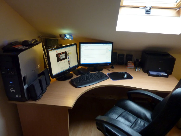 computer monitors and computers sit on a small desk