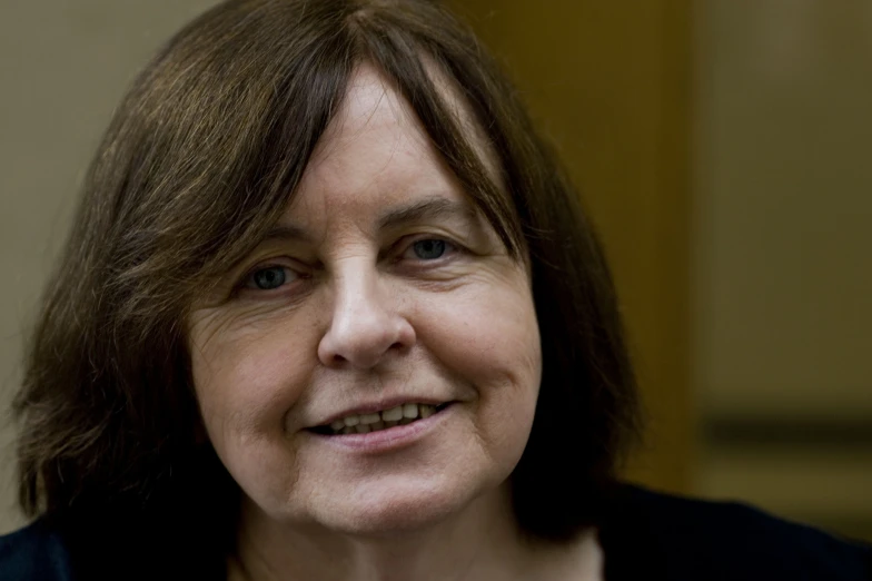 a woman with long hair smiles at the camera