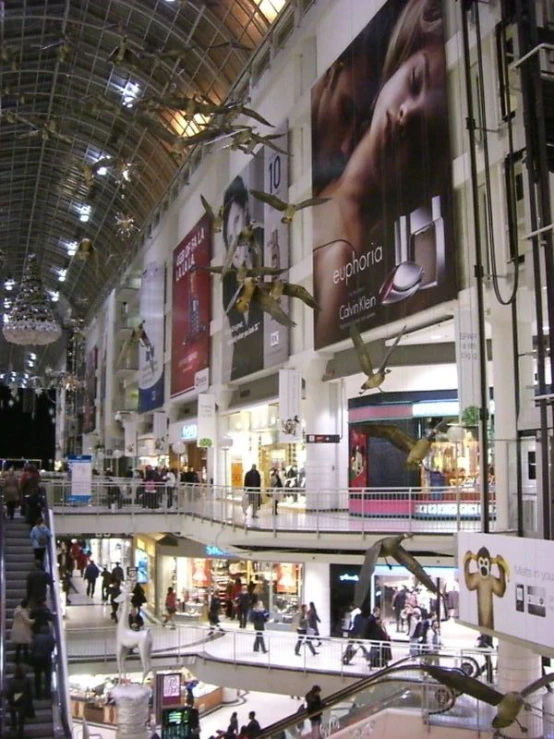 people walking around in a mall with a giant spider