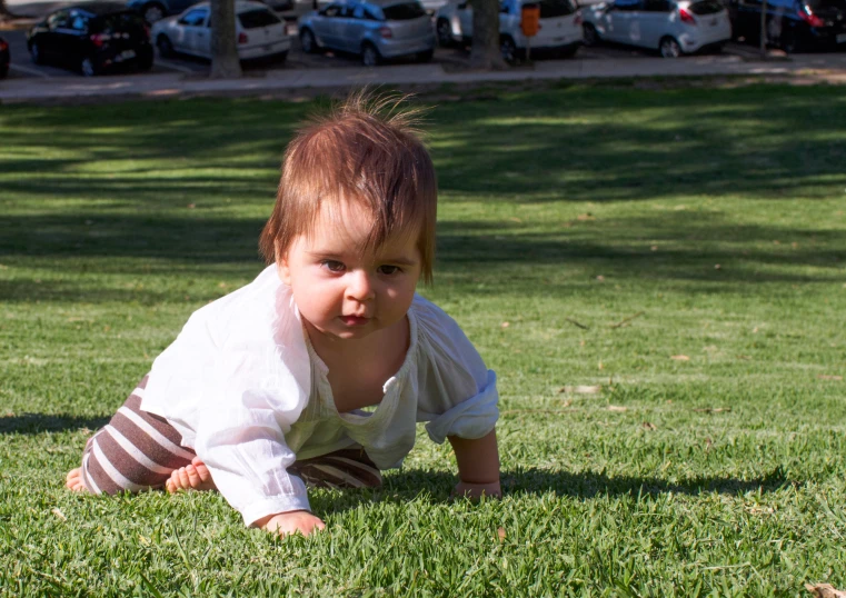 baby lying on the grass looking at the camera