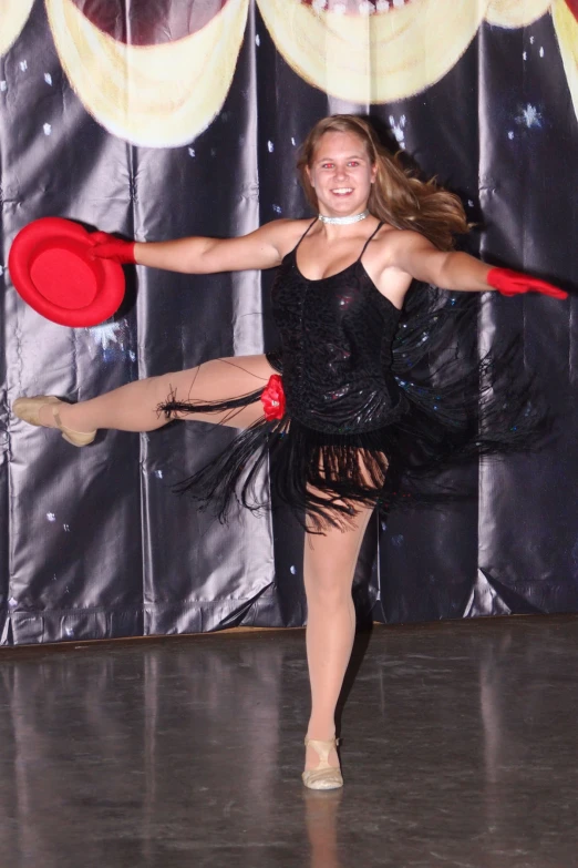 a woman dressed up dancing with her arms spread and a frisbee in her hand