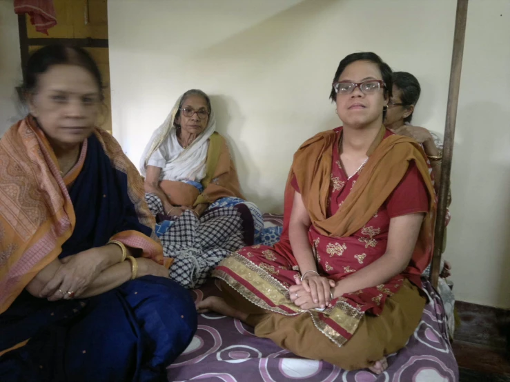 a group of women sitting on top of a bed