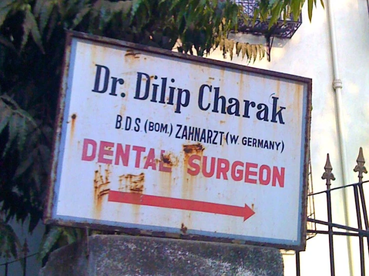 a sign for dental surgeon sitting on the side of a building