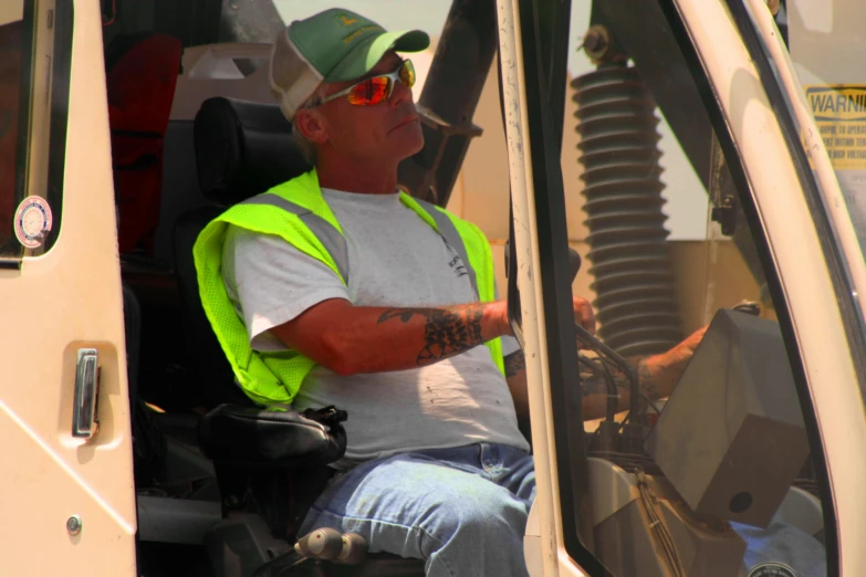 a man in reflective vest sitting in a vehicle