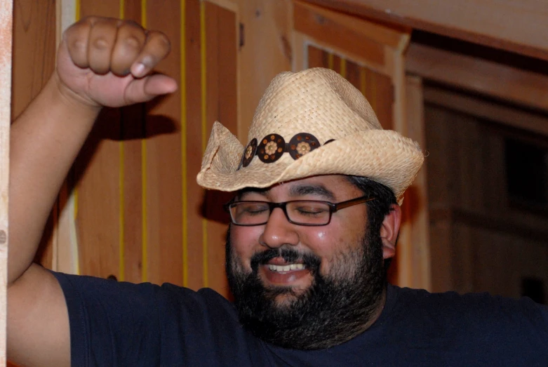 a man wearing a straw cowboy hat and glasses