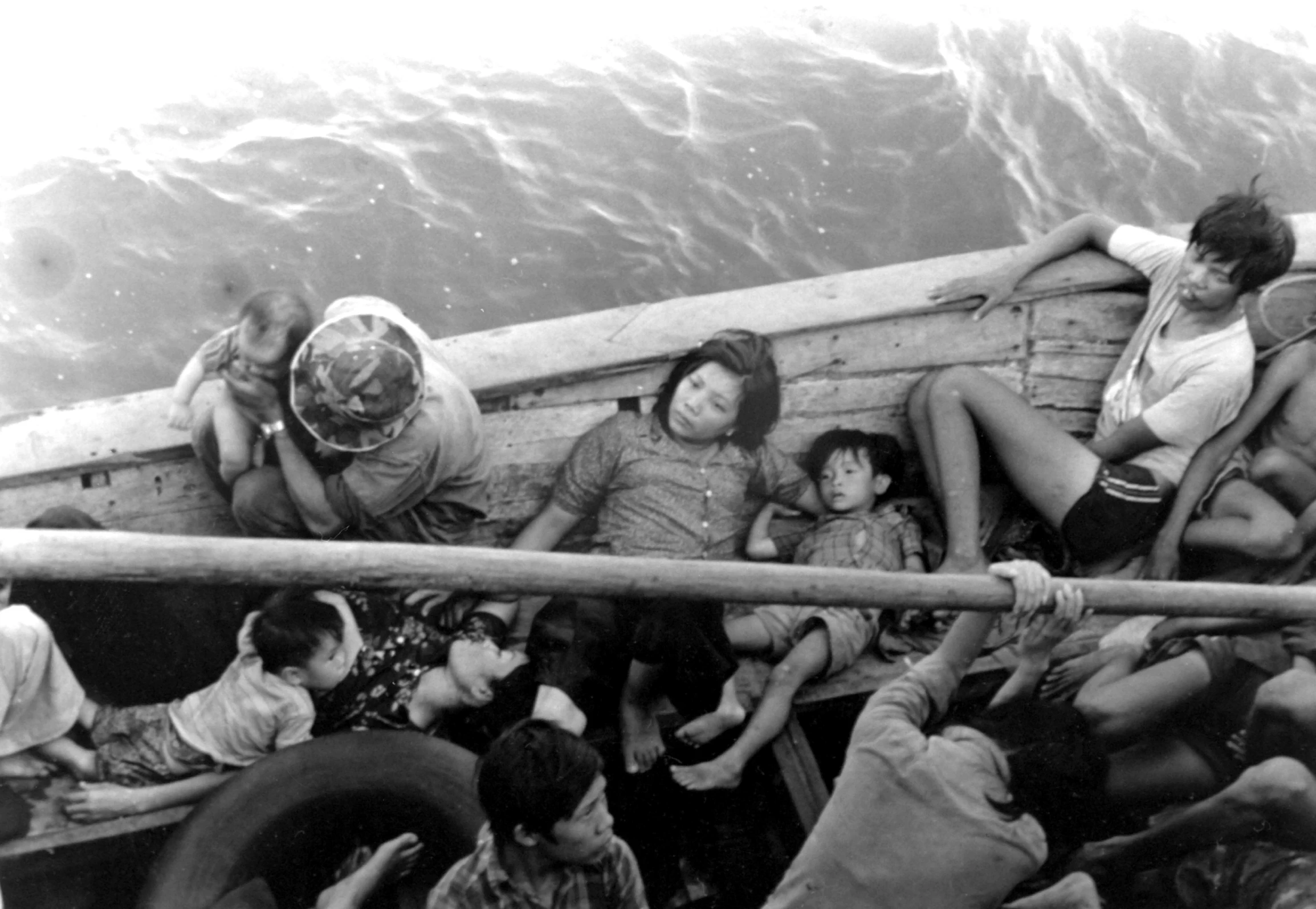 an old black and white po shows people in a rowboat