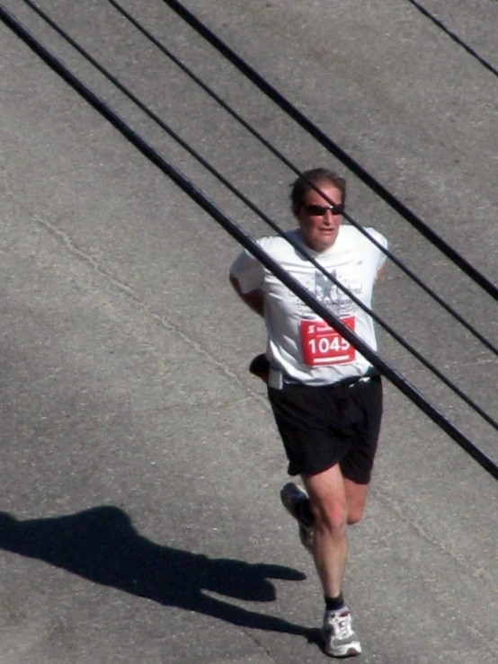 man in running vest during race with long poles