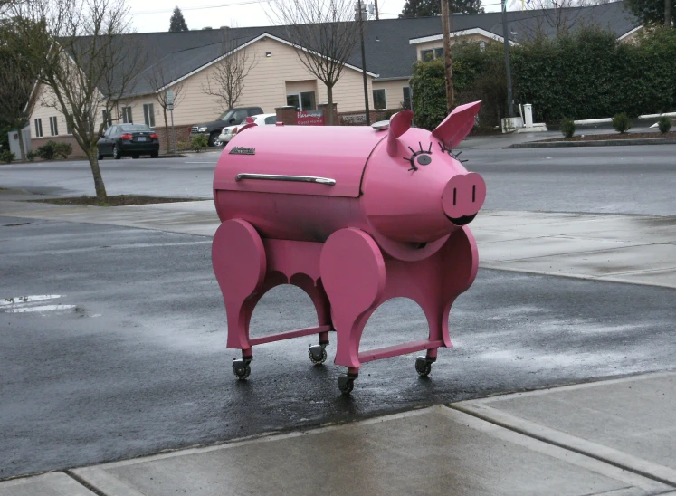 the pink pig has wheels on it in front of the street