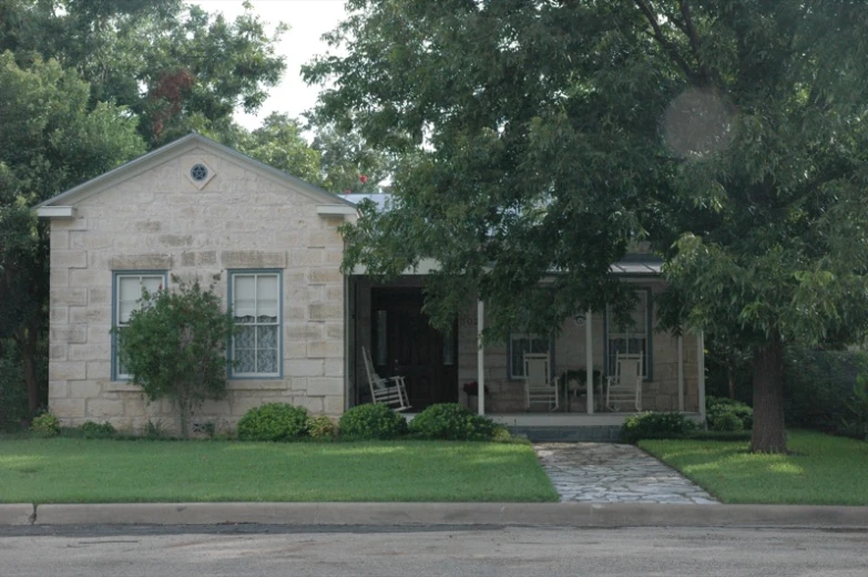 a home with brick accents and landscaping and a car parked in front of it