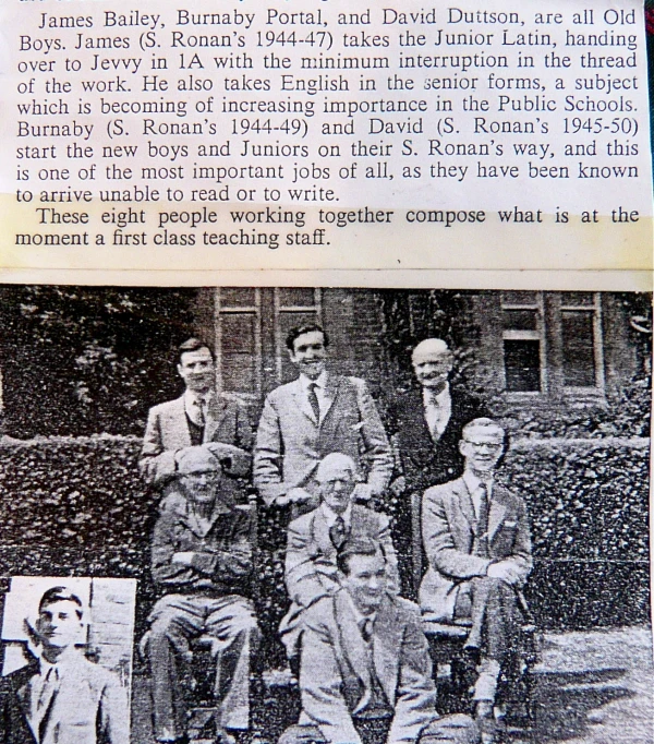 an old po of four men posing in front of a building