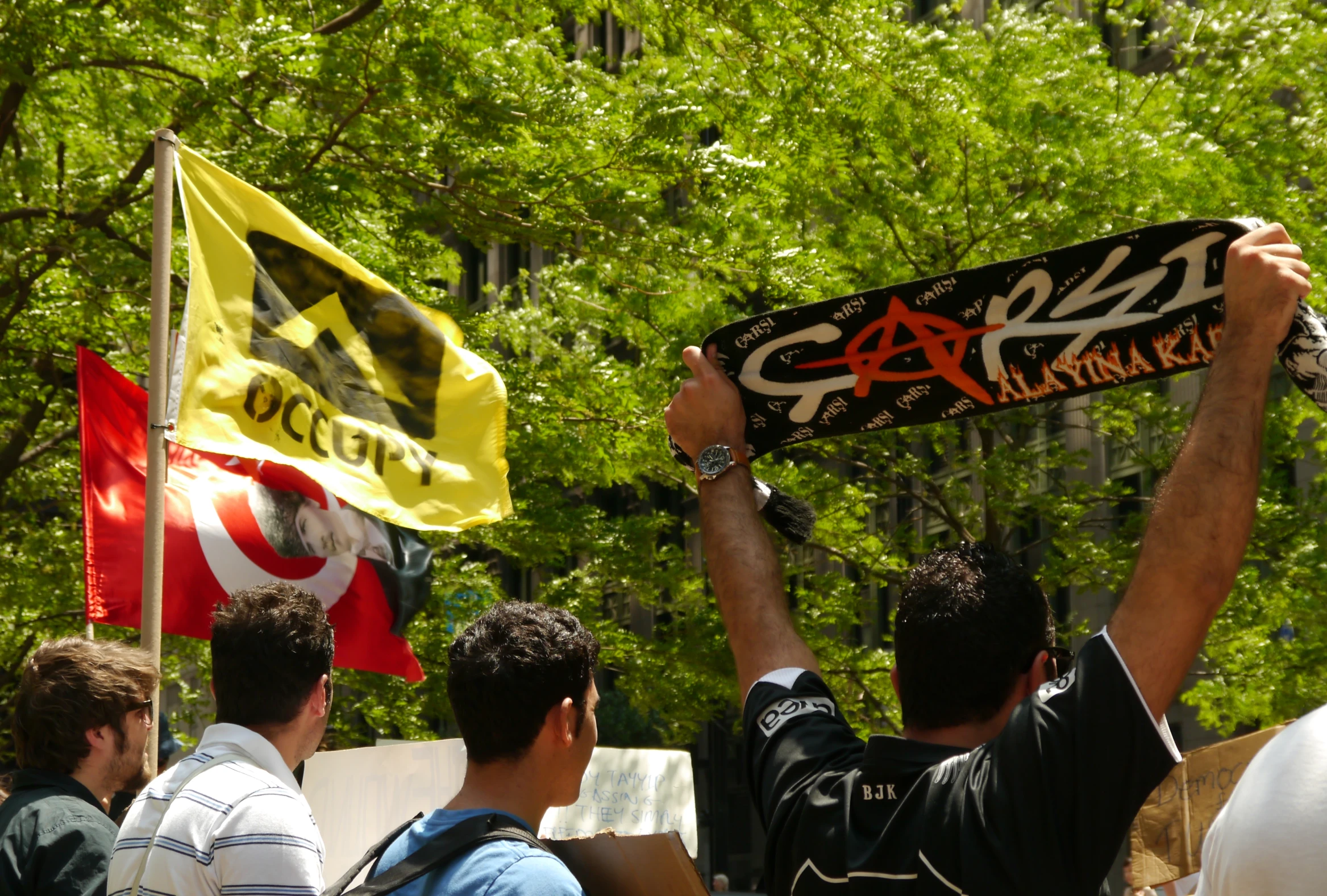 a man holds up his skateboard in the air