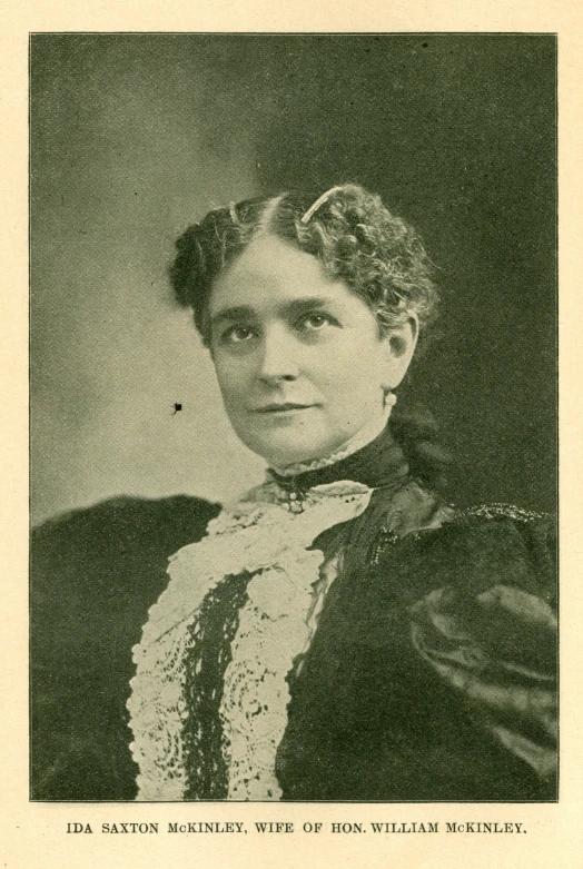 this old pograph shows a woman wearing an elegant suit