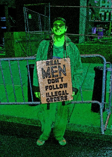a man in green shirt holding a sign