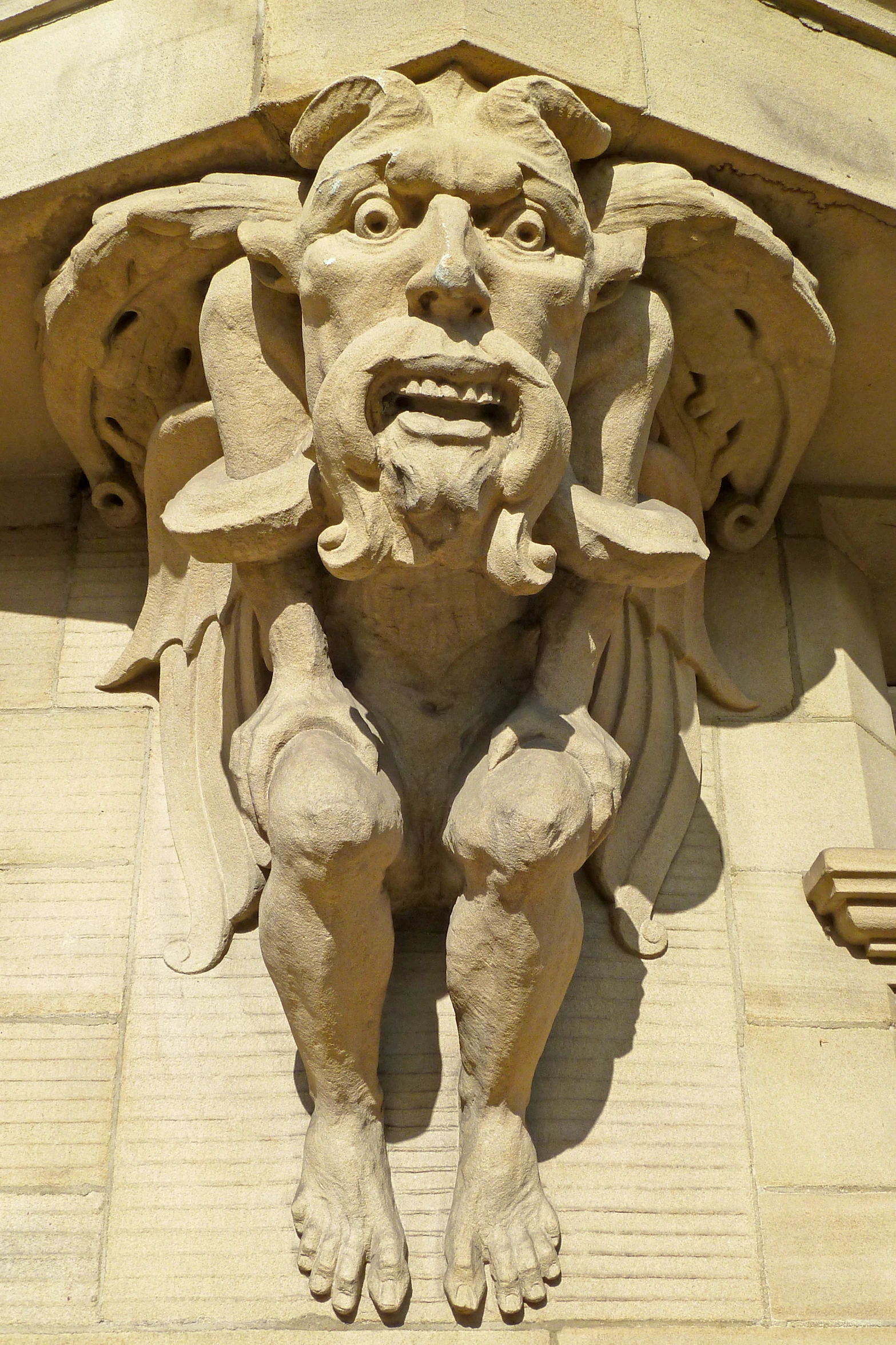 a stone gargoyle is on the side of a building