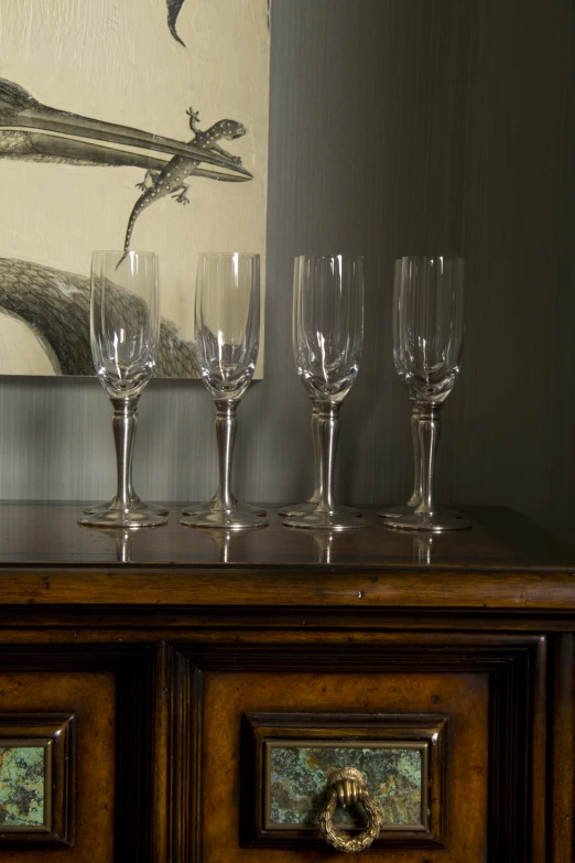 wine glasses sit on top of a cabinet in a corner