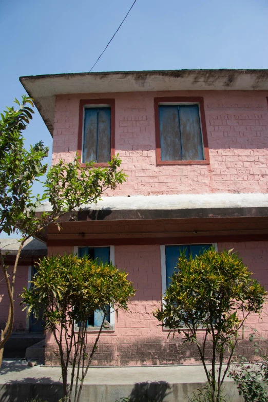 there is a large pink building with four windows