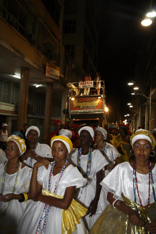 a group of women in white dresses standing together