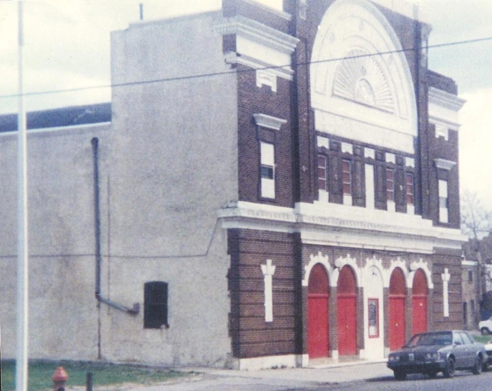 a car driving down a street next to a large building